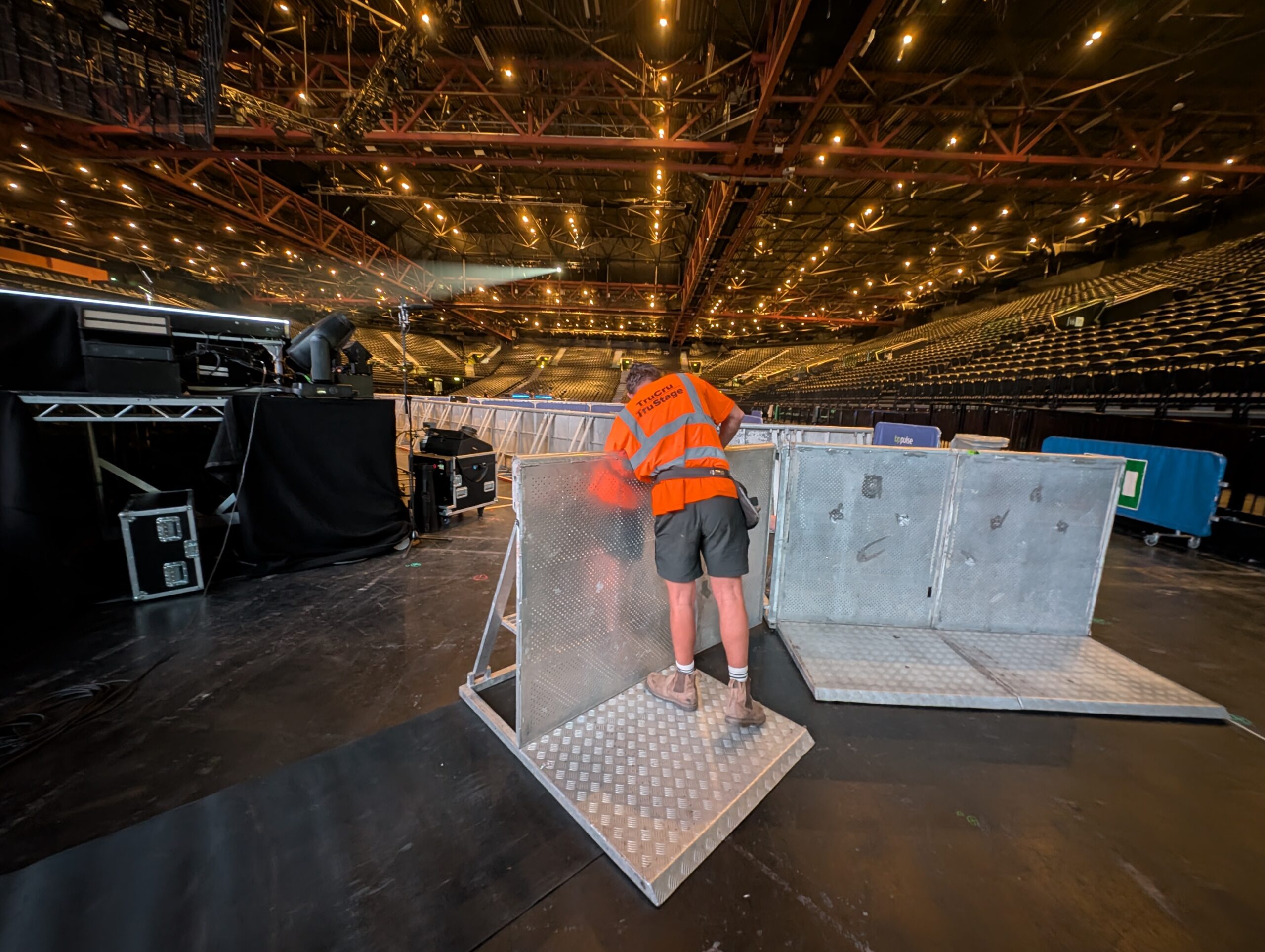 TruCru staff member putting finishing touches to barrier line on Mcfly Vs Busted Tour